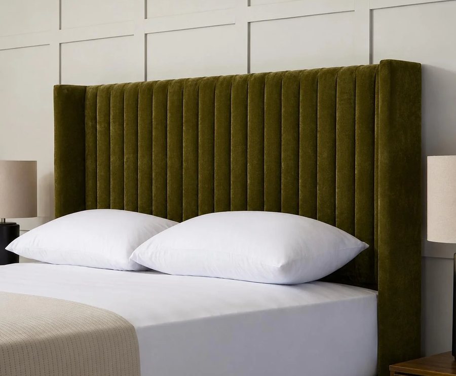 Bed with a tall green velvet headboard